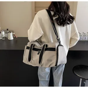 Detail der beige Reisetasche mit schwarzen Gurten und seitlichem Reißverschlussfach