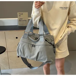 Detailansicht der grauen Nylontasche mit Reißverschlüssen und verstellbarem Schultergurt