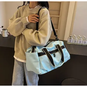 Hellblaue große Reisetasche mit verstellbarem Schultergurt, getragen von einem Model