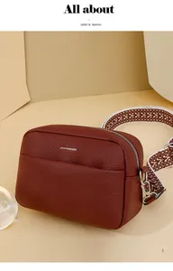 Détail du sac bandoulière bordeaux avec texture litchi et bandoulière tissée
