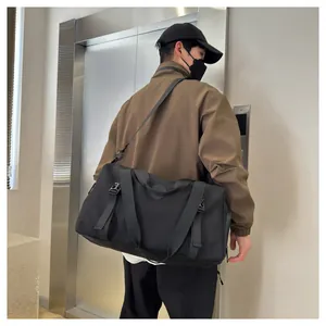 Detail of a black large capacity travel bag featuring reinforced nylon straps and side buckle