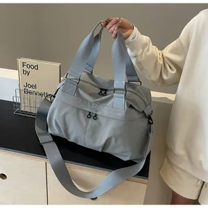 Detail von grauer Nylon-Tragetasche mit Doppelreißverschluss und Webgriffen