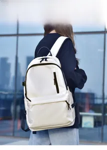 Outdoor model display of a white minimalist backpack with contrasting black zippers and straps