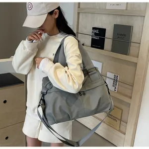 Detail der grauen Reisetasche aus Nylon-Canvas mit verstellbarem Gurt und Reißverschluss
