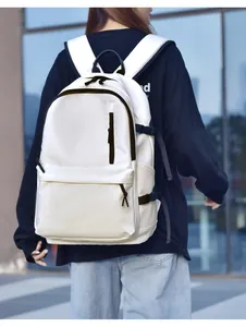 Rear view of model wearing a white minimalist large capacity waterproof backpack outdoors