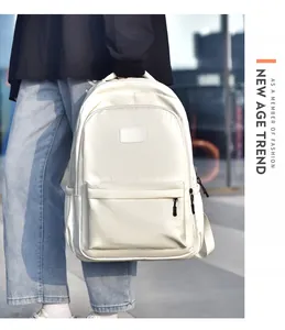 Gros plan du sac à dos en nylon ivoire avec poche zippée avant et compartiment latéral