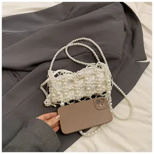 Détail du sac en perles fait main avec pochette montrant la capacité pour un téléphone