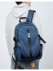 Detail view of water-resistant navy blue backpack showing side pocket and reflective strips
