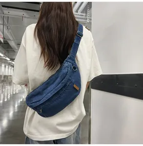 Detail of adjustable strap and vintage washed blue denim fabric on the crescent chest bag