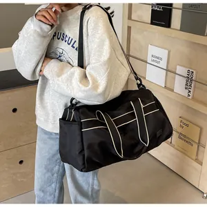 Große schwarze Reisetasche aus Nylon mit Kontrastgriffen getragen von einem Modell