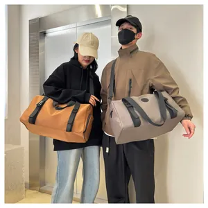 Waterproof travel bags in tan and grey colors held by models in a modern elevator