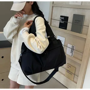 Detailansicht der schwarzen Nylontasche mit breiten Griffen und verstellbarem Gurt