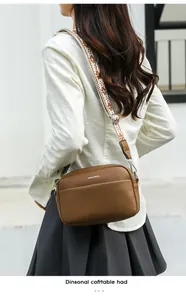 Sac bandoulière en cuir marron avec large sangle ethnique porté par un mannequin