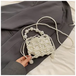 Détail du sac de soirée tissé en perles avec pochette en satin et poignée florale