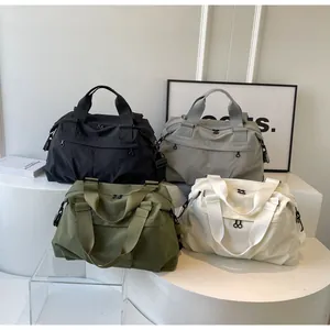 Detailansicht großer Nylon-Tragetaschen in Schwarz, Grau, Olivgrün und Off-White
