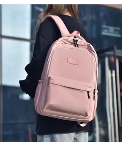 Sac à dos rose en nylon imperméable avec bretelles rembourrées sur un modèle
