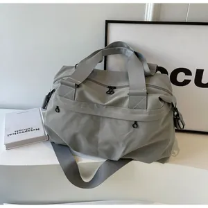 Detailaufnahme der grauen Nylontasche mit Doppelreißverschluss und Web-Schultergurt