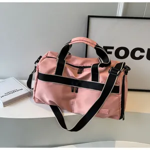 Detailansicht der rosa Reisetasche mit schwarzen Tragegriffen und NINGJIA Markenetikett