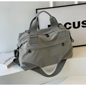 Detail der grauen Nylon-Reisetasche mit verstärkten Griffen und verstellbarem Gurt