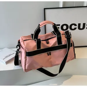 Detailansicht der pinkfarbenen wasserdichten Reisetasche aus Nylon mit verstärkten Tragegurten