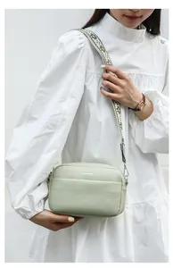 Détail du sac bandoulière vert clair en cuir grainé avec large sangle tissée