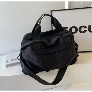 Detailansicht der schwarzen Reisetasche aus Nylon mit Ring-Reißverschlüssen und Gurt