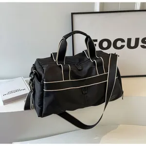 Nahaufnahme der schwarzen Nylon-Reisetasche mit weißen Kontrastgurten und Schultergurt