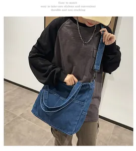 Vista dettagliata della grande borsa tote in denim blu scuro con tasche e tracolla larga