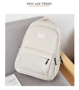 Détail d'un sac à dos minimaliste blanc crème imperméable posé sur un canapé gris doux
