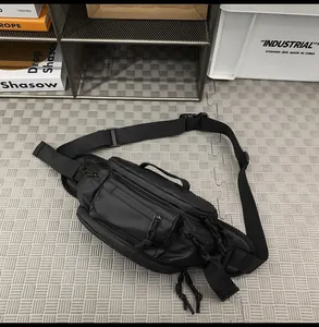 Detail of waterproof black tactical chest bag showing multi-zipper layers and paracord pulls