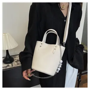 Detail of off-white bucket bag with lychee texture and silver chain with bead charms