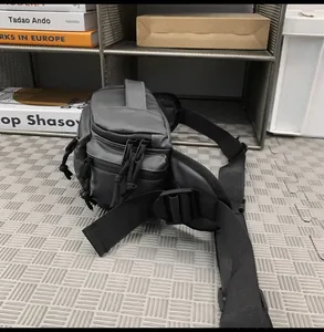 Detail of dark grey tactical crossbody bag showing waterproof nylon and heavy-duty handles