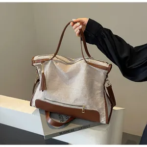 Detailed close-up of the canvas texture and leather trim with stylish tassel charm