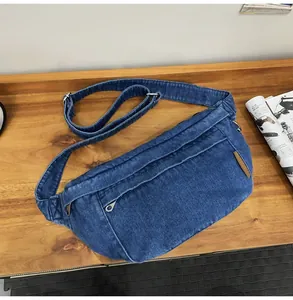 Detail van blauwe denim borsttas met gewassen textuur en zilveren metalen gesp sluiting