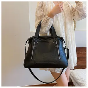 Détail du sac cabas en cuir grainé noir avec double fermeture éclair et bandoulière
