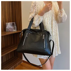 Détails du sac cabas en cuir souple noir avec fermetures éclair sur un mannequin chic