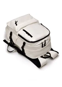 Top view of white nylon backpack featuring multiple zippers and adjustable side straps