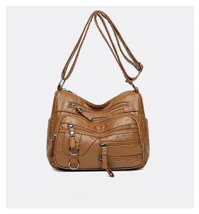 Détail du sac bandoulière marron en similicuir avec plusieurs poches zippées devant