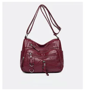 Détail du cabas en cuir PU rouge avec fermetures éclair multiples et texture grainée