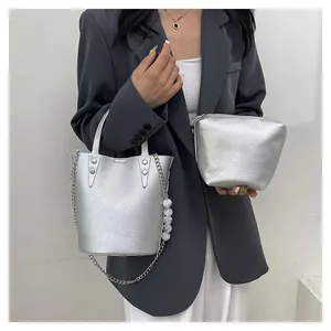 Silver lychee grain bucket bag with chain strap and pearl charm on a fashion model