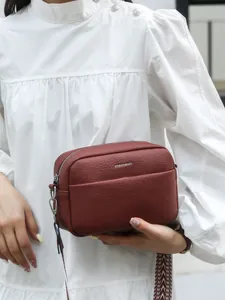 Sac bandoulière tendance en cuir bordeaux avec large bandoulière tissée
