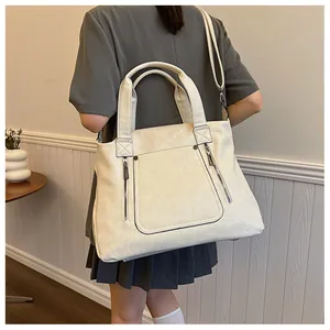 Détail du grand sac cabas crème en cuir rétro avec poches latérales zippées élégantes