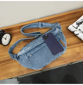 Detailweergave van een vintage denim borsttas op houten bureau met lifestyle accessoires