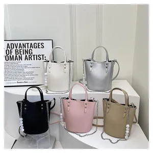 Detail of five multi-color bucket bags with lychee texture and pearl chain straps