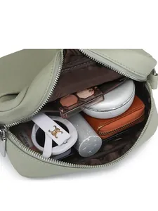 Intérieur du sac à bandoulière en cuir vert montrant la capacité de rangement spacieuse