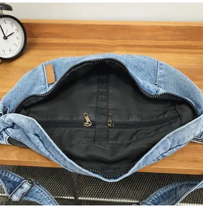 Macro view of light blue denim sling bag interior with spacious compartment and zipper
