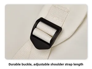 Détail de la boucle en plastique noir avec bandoulière de sac à dos blanche réglable