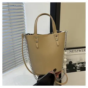 Detail of beige bucket bag with pebble leather texture and marble bead metal chain