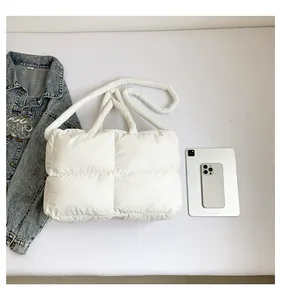 Vue à plat du grand sac fourre-tout matelassé blanc avec accessoires montrant sa capacité
