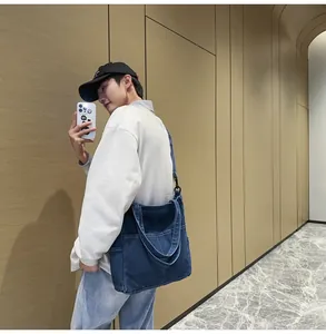 Dettaglio macro della borsa tote in denim con tasche esterne e tracolla rimovibile